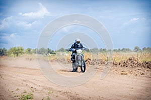 Enduro bike racer driving on dirt motocross dust track