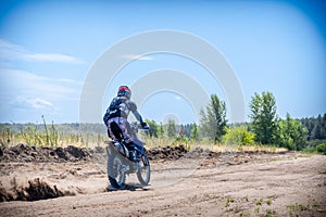 Enduro bike racer driving on dirt motocross dust track