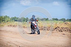 Enduro bike racer riding on a dirt motocross road