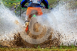 Enduro Motocross mud,Motocross racer in a wet and muddy terrain covering the driver completely.