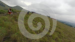 Enduro motorbike riders group driving mountain ridge tourist place big red letters