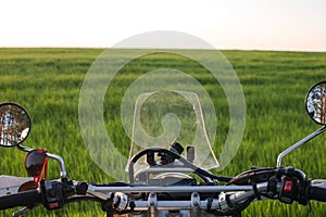 Enduro off road Motorcycle on green grass hill landscape pine forest sunset