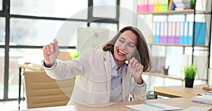 Energetic businesswoman dancing joyfully in a modern office