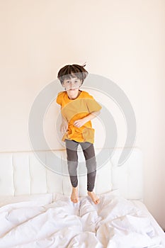 An energetic child is jumping on the bed