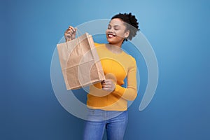 energetic cute young 25 year old hispanic lady holding out a craft shopping bag