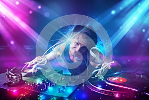 Energetic Dj mixing music with powerful light effects