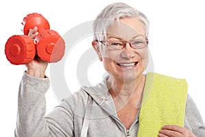 Energetic elderly woman with dumbbells smiling