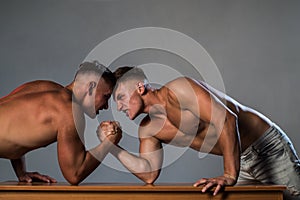 Energetic and full of strength. Twins men competing till victory. Revenge in sport. Twins competitors arm wrestling. Men