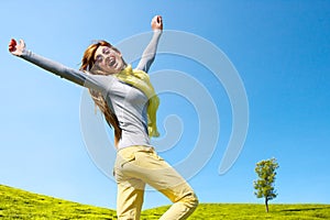 Energetic girl with open arms outdoors.