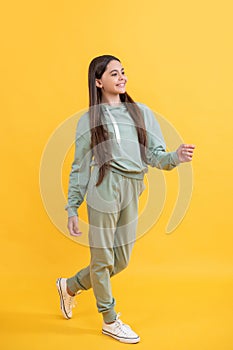Energetic girl in a sportsuit go to sport gym having active childhood lifestyle