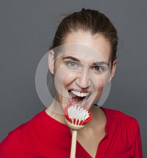 Energetic gorgeous girl holding dish brush as micro