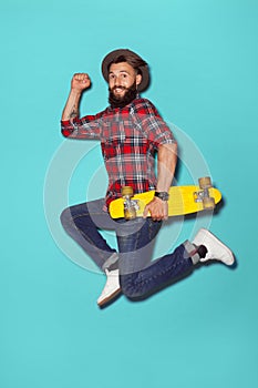 Energetic hipster jumping with longboard