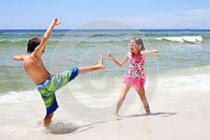 Energetic little children fighting on beach at sea