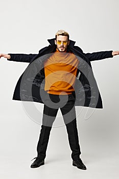 energetic man in a coat spread his arms to the sides and pants orange sweater model