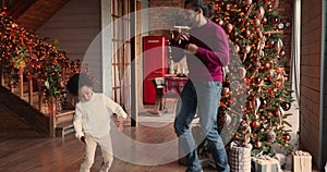 Energetic mixed race family dancing together in living room.