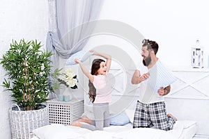 Energetic and positive. Energetic daughter and father play game. Pillow fight. Happy family in energetic mood. Staying