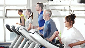 Energetic senior woman exercising on treadmill.