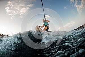 man holds rope and catches a wave on wakesurf. Wakesurfing on the river. photo