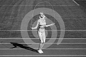 energetic woman jumping with rope. sporty girl in sportswear jump on skipping rope.