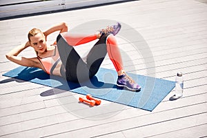 Energetic woman is training abdomen outdoors