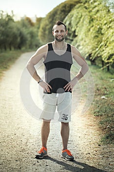 Energetic young man do exercises outdoors and running in park to