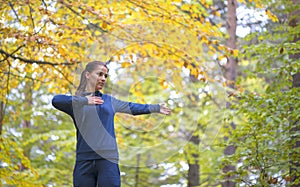 Energetic young woman do exercises outdoors in park to keep their bodies in shape