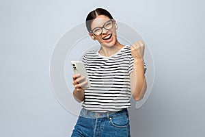 Energized woman with earphones holding a phone and listening music fully enjoying it