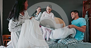 Energy, bedroom and kids in a pillow fight with their parents for fun, playful or bonding together. Happiness, smile and