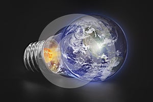 Energy Concept - Save energy, planet Earth in a light bulb on a black background