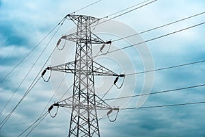 Energy crisis concept, electricity pylon with overhead powerline cables against dramatic overcast sky