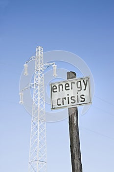 Energy Crisis written on road sign near electricity pole