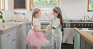 Energy, dance and children friends in the kitchen spinning, playing and bonding in modern home. Happy, playful and young