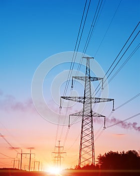 Energy Distribution Network - Electricity Pylons against Orange and Yellow Sunset.