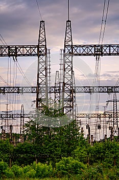 Energy distribution network. Electricity pylons against orange and yellow sunset. Selective focus.