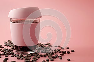Energy drinks, morning routine and stimulant beverages concept glass and rubber cup of java surrounded by roasted coffee beans photo