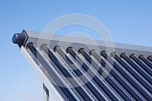 Energy efficiency concept. Closeup of vacuum solar water heating system on the house roof