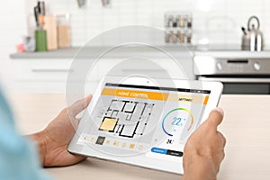 Energy efficiency home control system. Man using tablet to set temperature, closeup