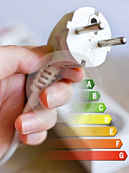 Energy efficiency label for house / electricity and money savings - plug in a hand