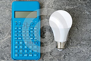 Energy efficient light bulb and blue modern calculator