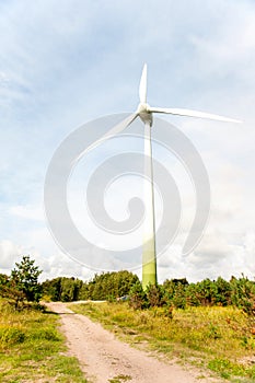 Energy generator wind turbine on dramatic cloudy blue sky background