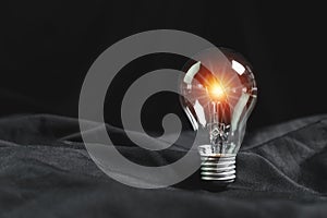 Energy innovation concept. light bulb on black background with light fair. power energy ecology solution saving global warming,