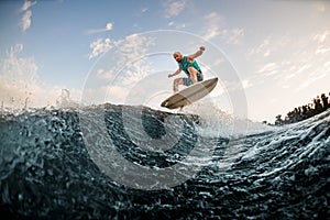 Energy man jumping on wakeboard down the river waves. Wakesurf training