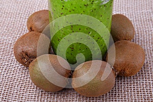 Energy morning green smoothie with kiwi on a white tablecloth closeup. Fresh kiwi fruit for sweet beverages or desserts.