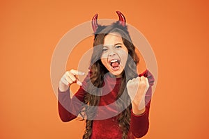 Energy and power. Halloween costumes designed after supernatural figures. Little girl red horns celebrate Halloween