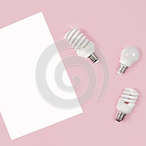 Energy-saving and eco-friendly life in conceptual frame pattern. Creative top view flat lay of LED light bulbs and white paper