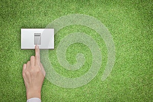 Energy saving and ecological friendly concept with hand turning off switch on green grass lawn