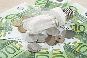 Energy saving fluorescent lamp on money background, Eco light bulb, comparison of energy saving lamps and incandescent