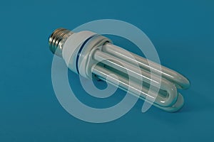 Energy saving fluorescent light bulb close-up on a blue background