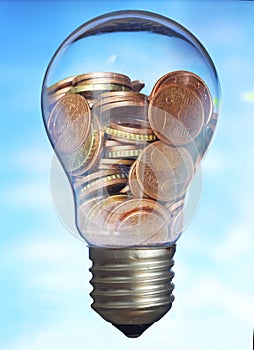 Energy saving, heap of coins in light bulb.Efficient use of energy, environmental conservation,