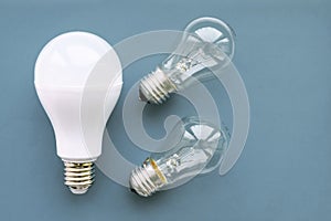 Energy-saving lamp with incandescent lamps on a gray background. The concept of saving energy